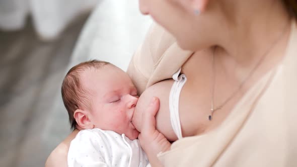 View From Above on Young Mother Looking and Rocking Her Newborn Baby Sucking Milk From Breast, Stock Footage