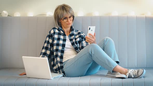 A Beautiful Grayhaired Middleaged Woman with Someone is Having Fun Talking and Laughing on the Phone