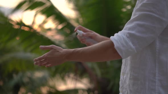 Superslowmotion Shot of a Young Man Applying an Antimosquito Repellent Spray on His Skin alt