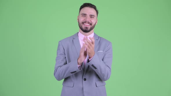 Happy Young Bearded Businessman Clapping Hands alt