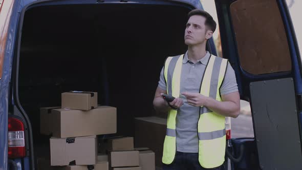 Delivery man scanning boxes with barcode scanner