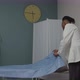 Male Physician or Nurse Covering Diagnostic Bed with New Sheet Indoors - VideoHive Item for Sale