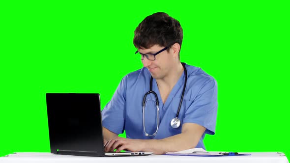 Friendly, Happy Male Doctor in the Office Using Laptop. Green Screen alt