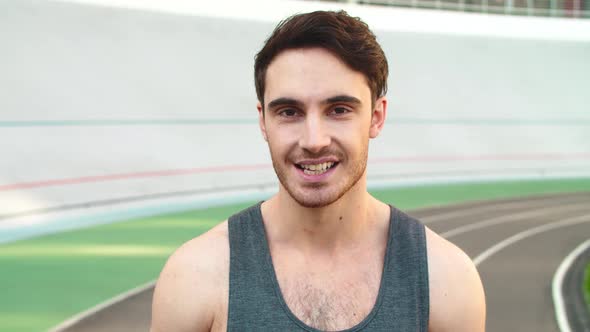 Closeup Athlete Man Smiling on Track. Portrait of Runner Standing on Track alt