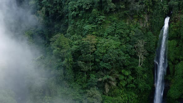 Moving Through Mist to Reveal a Large Waterfall