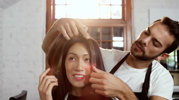 Male hairdresser styling a womans hair alt