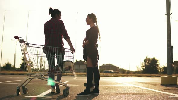 Young Attractive Girl in Long Socks is Holding a Skateboard and Talking to Her Girlfriend That is alt
