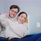 a Smiling Young Couple Using Laptop at Home Indoor - VideoHive Item for Sale