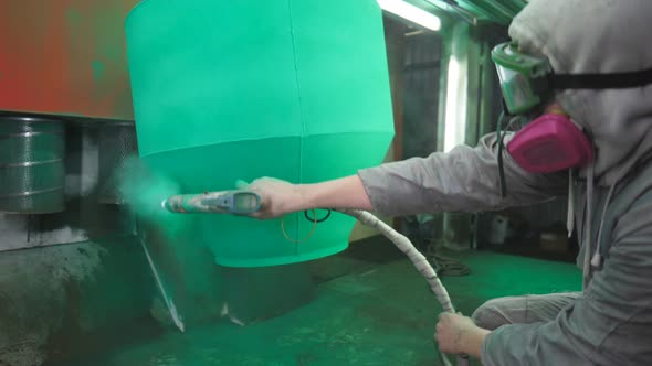 Painter Spraying Green Paint on Detail in Special Booth alt