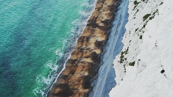 Coastline Aerial Drone of Ocean Waves Breaking on Sandy Beach by White Chalk Cliffs on Coast showing alt