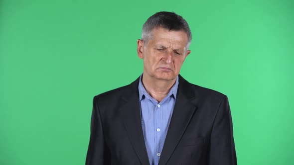 Portrait of Aged Man Is Upset Isolated Over Green Background. alt