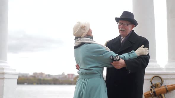 Senior man and woman dancing together in the park. The concept of a healthy lifestyle. alt