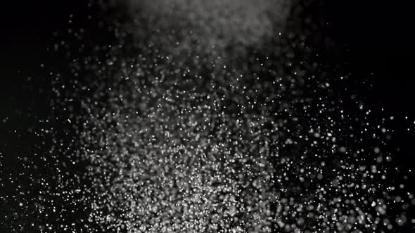 Dusting flour on black background. Slow Motion. alt