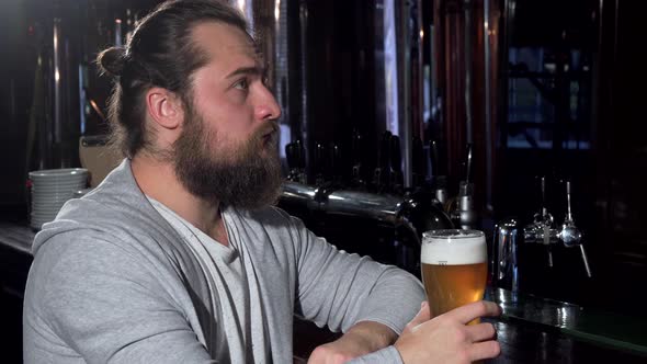 Bearded Long Haired Man Looking Depressed, Drinking Beer Alone at the Bar alt