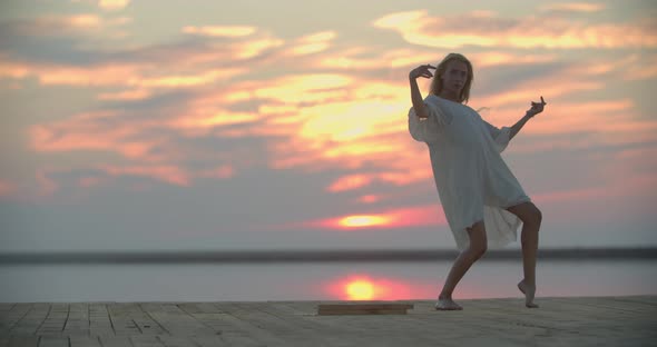Sexy Dance on the Pier of a Lake During Sunset Woman in White Dress alt