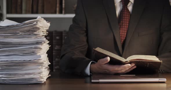 Businessman Reading Book on His Office Desk