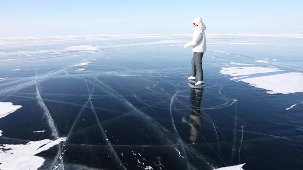 Girl Skates on The Transparent Ice of Lake Baikal