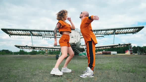 A Stylish Couple in Orange Clothes Is Dancing alt