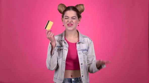 Teen in a Pink Topic with a Credit Card Is Happy. Pink Background alt