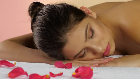 Woman Sleeps and Rest After Spa Treatments on Rose Petals alt