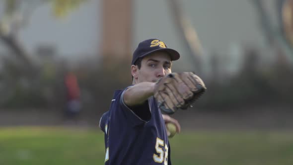 A young man playing catch with a baseball. alt