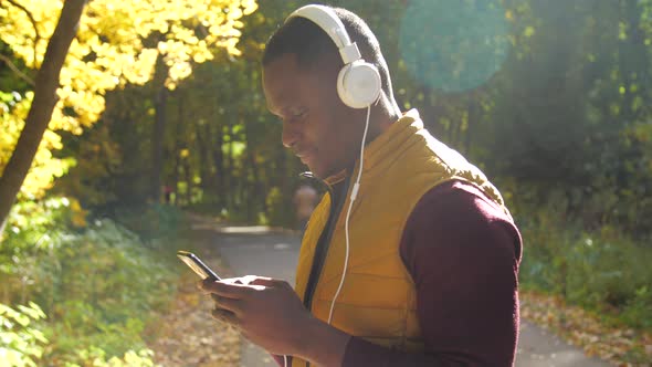 Concept of Listening To Music and Podcasts. Smiling Young African American Man Listens Music in a alt