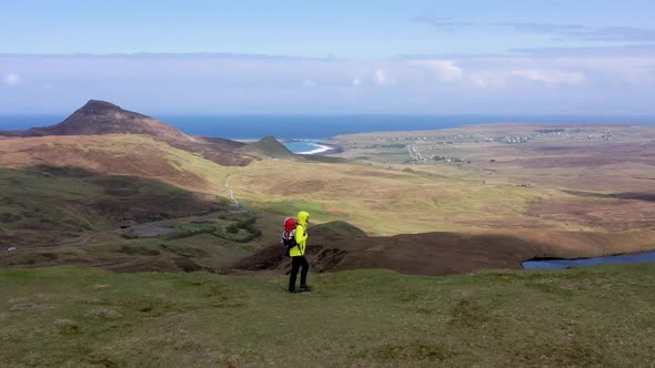 Man adventurer with backpack exploring Isle of Skye alt