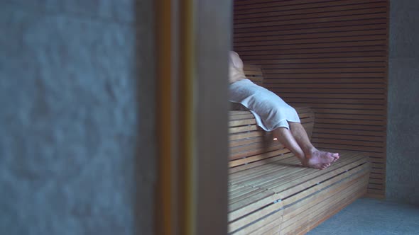 A man relaxes in a sauna at a luxury resort. alt