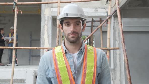 Portrait of Asian man engineer at building site looking at camera
