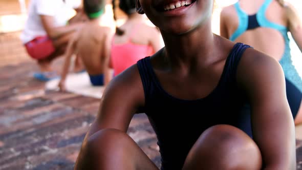 Smiling girl sitting near poolside alt