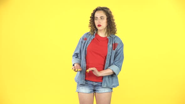 Girl Strictly Gesturing with Hands Shape Meaning Denial Saying NO with Smile. Yellow Background at alt