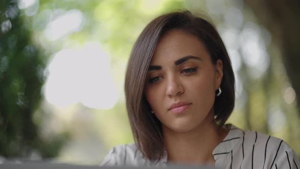 Portrait Serious Woman Brunette Arabic Hispanic Ethnic Group Sits at a Table in a Summer Cafe with a alt