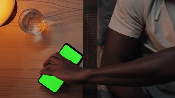 American American Man Using Mobile with Green Screen Before Fall Asleep