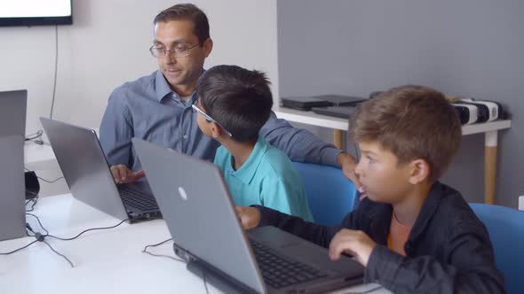 Computer Science Teacher Teaching Schoolboys To Write Codes alt