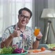 Smiling Asian Man Holding A Glass Of Orange Juice And Showing Thumbs Up - VideoHive Item for Sale