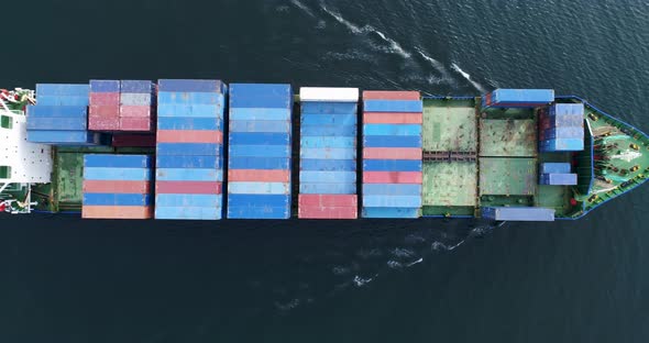 Aerial top view of cargo container ship vessel import export container sailing. alt