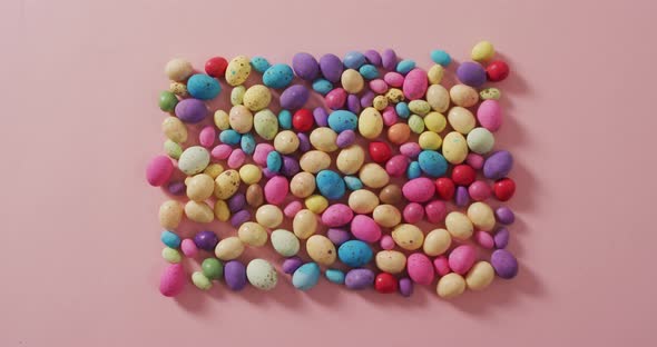 Video of decorated colorful easter eggs on a pink surface alt