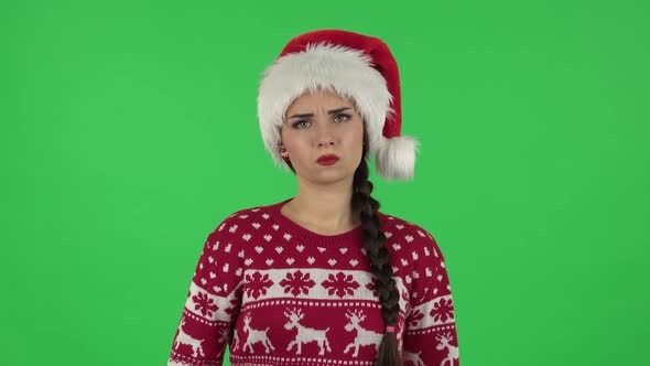 Portrait of Sweety Girl in Santa Claus Hat Is Standing Offended and Then Smiling. Green Screen alt