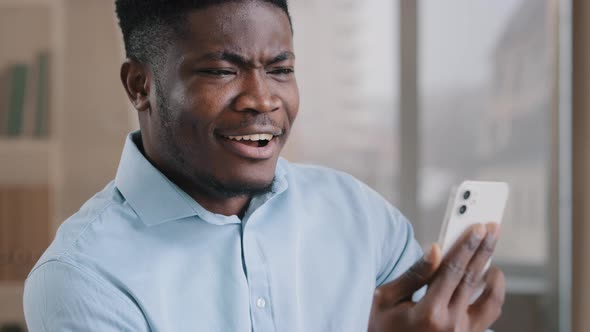 African Male Surprised Amazed Millennial 30s Man Worker Talking Remote on Mobile Phone Handsome alt