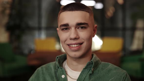 Crop View of Young Man with Stylish Haircut Smiling While Looking to Camera alt