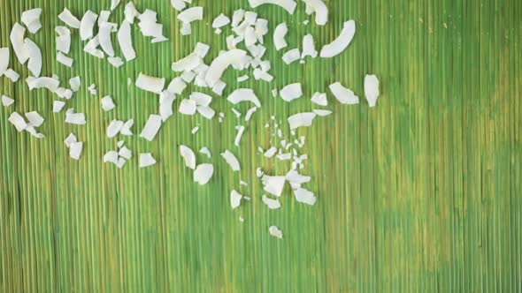 Dehydrated coconut flakes on a wood background alt