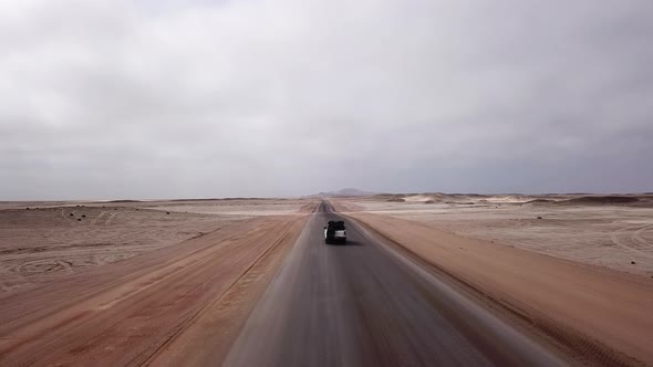 Car Driving on Gravel Road in Aerial Desert
