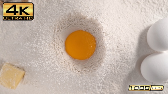 Raw Egg Yolk Falling into Flour alt