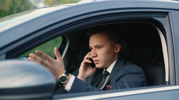 Stressed Businessman Calling on a Mobile Phone in the Car alt