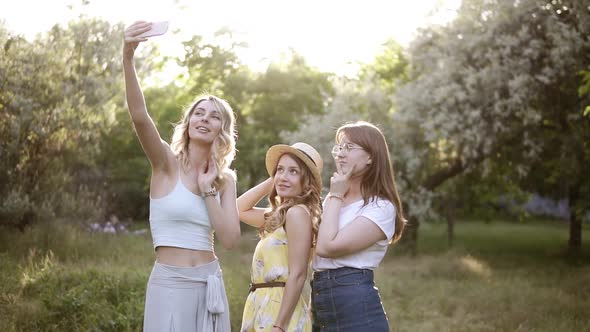Front View of Three Young Women Making Selfie with Mobile Phone Posing alt