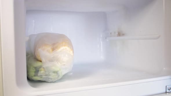A Man Puts Plastic Containers in the Fridge