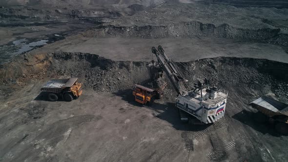 Loading Queue From Giant Dump Trucks to Mining Excavator