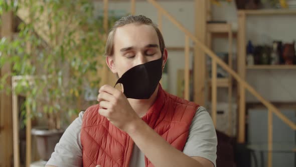 A Handsome Man is Putting Off His Face a Protective Mask alt