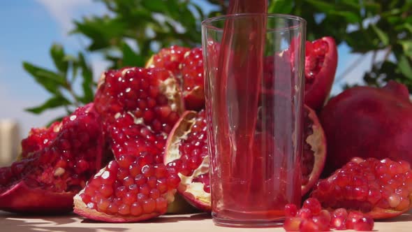 Fresh Pomegranate Juice Wave is Flowing Into a Jug in Slow Motion alt