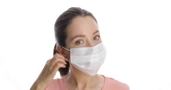 Portrait of Caucasian Young Woman in Medical Mask Standing on the White Background